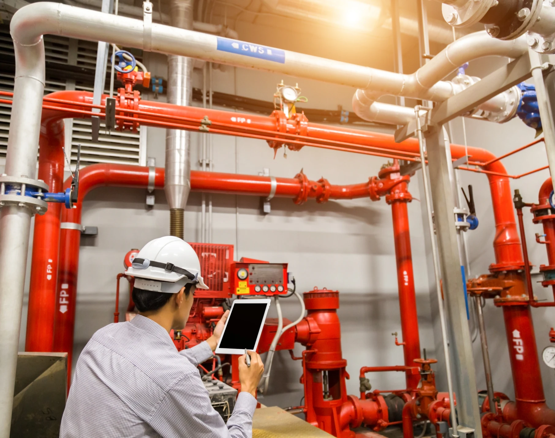 Worker analyzing red industrial piping system