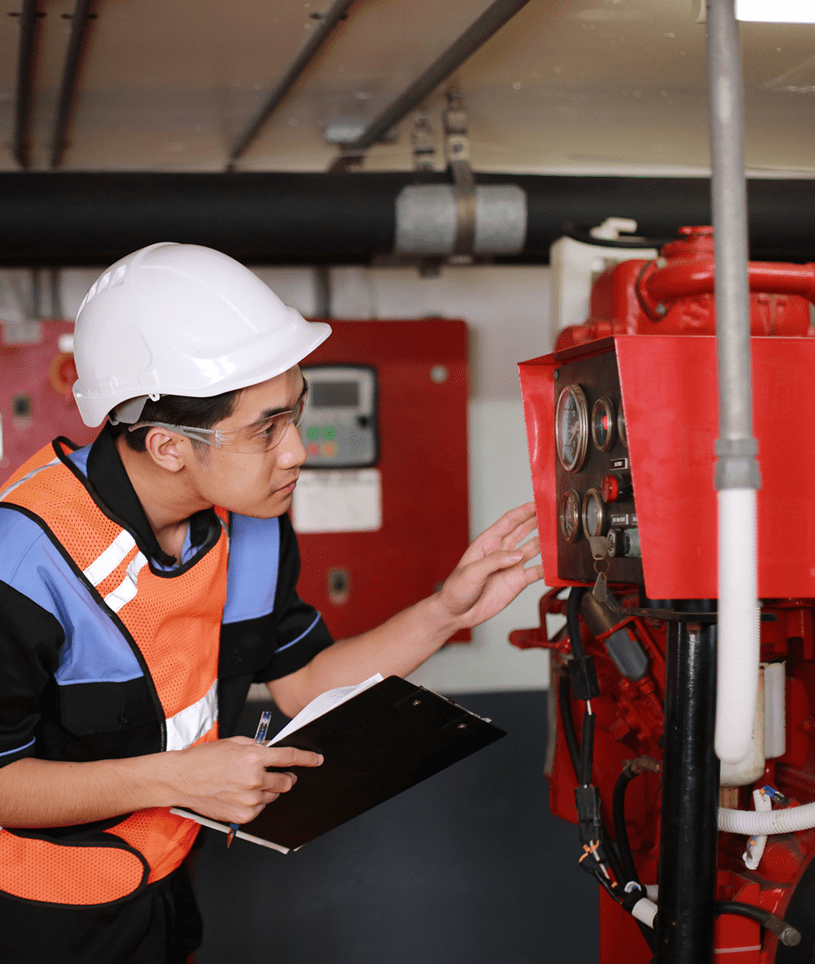 Worker in hard hat examines gauges